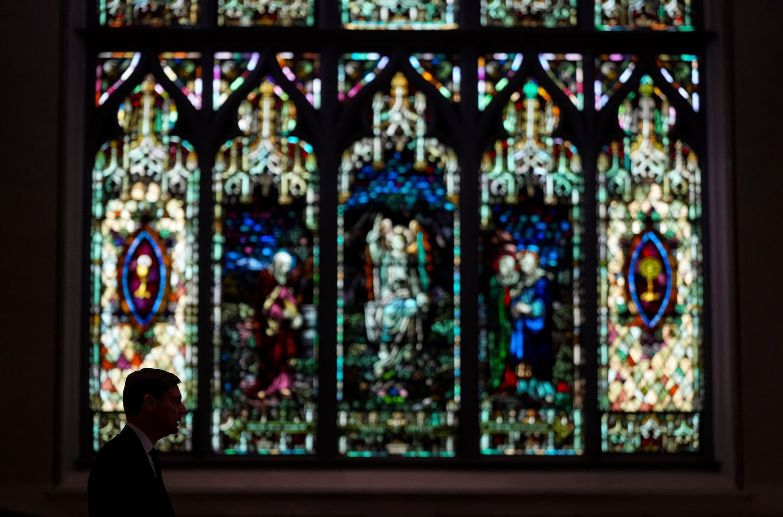 B.C. Premier David Eby is silhouetted while speaking after mass at Holy Rosary Cathedral on a provincial day of mourning for the victims of the vehicle-ramming attack at the Filipino community's Lapu Lapu Day festival last week, in Vancouver, on Friday, May 2, 2025. (Darryl Dyck/The Canadian Press via AP)