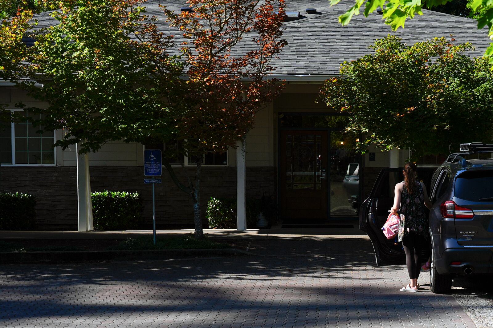A guardian drops off a child at the Guidepost Montessori school on Friday, July 18, 2025, in Beaverton, Ore. (AP Photo/Jenny Kane)