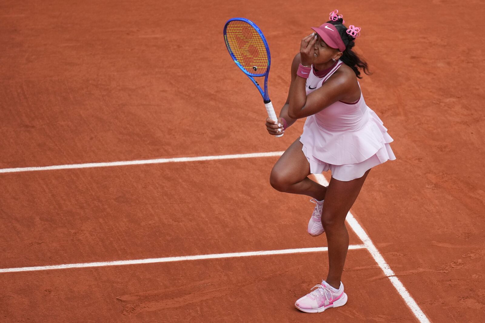 Japan's Naomi Osaka reacts as she plays Spain's Paula Badosa during their first round match of the French Tennis Open, at the Roland-Garros stadium, in Paris, Monday, May 26, 2025. (AP Photo/Christophe Ena)