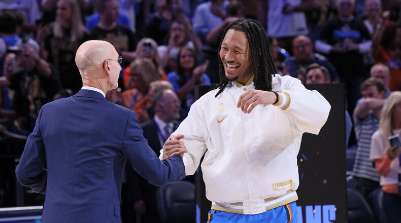 Oklahoma City Thunder forward Jaylin Williams, right, greets NBA commissioner Adam Silver during the championship ring ceremony before an NBA basketball game against the Houston Rockets, Tuesday, Oct. 21, 2025, in Oklahoma City. (AP Photo/Nate Billings)