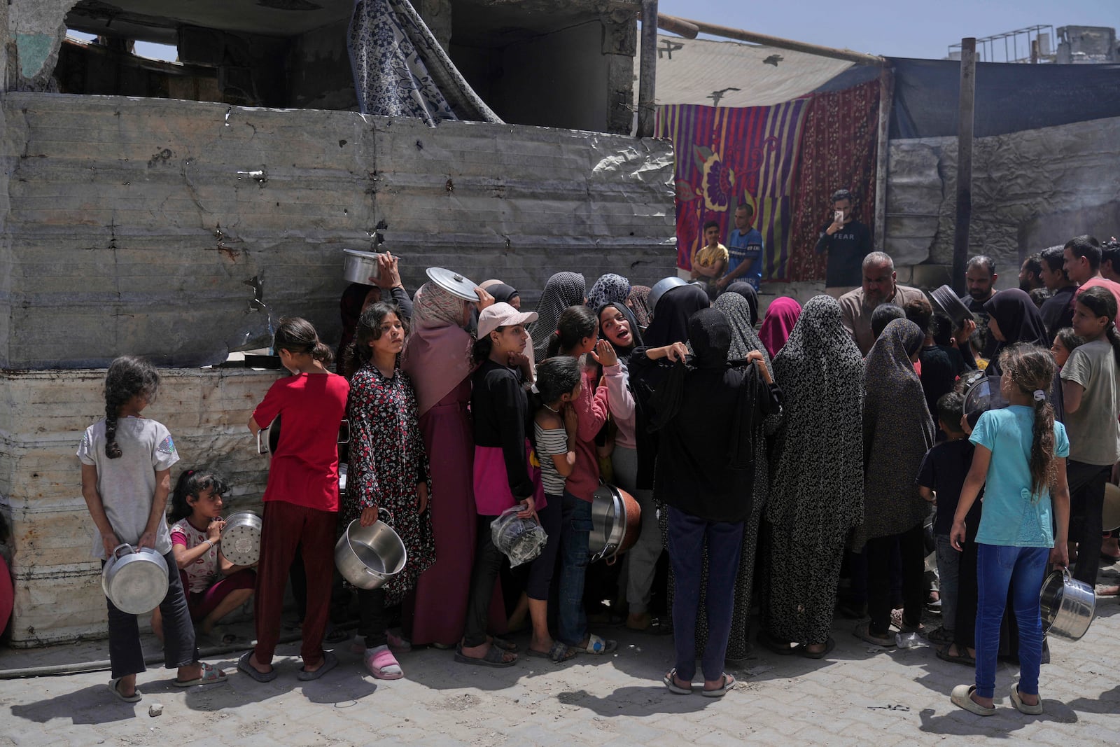 Palestinians line up for donated food at a community kitchen in Jabalia, in the northern Gaza Strip, on Monday, May 19, 2025. (AP Photo/Jehad Alshrafi)