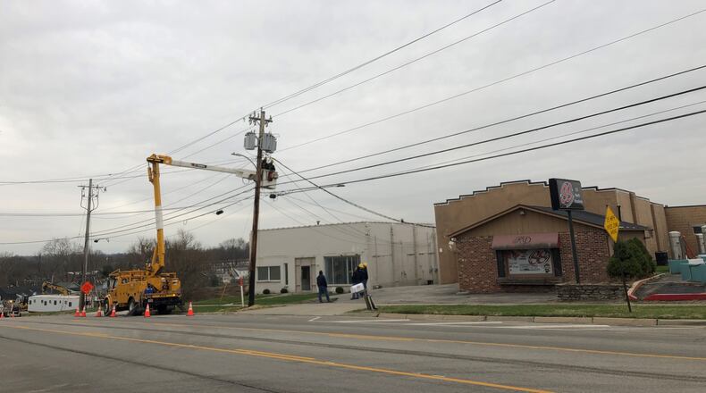 City workers adjust electric service on poles in front of two properties envisioned as part of the redevelopment of Lebanon's former city garage site.