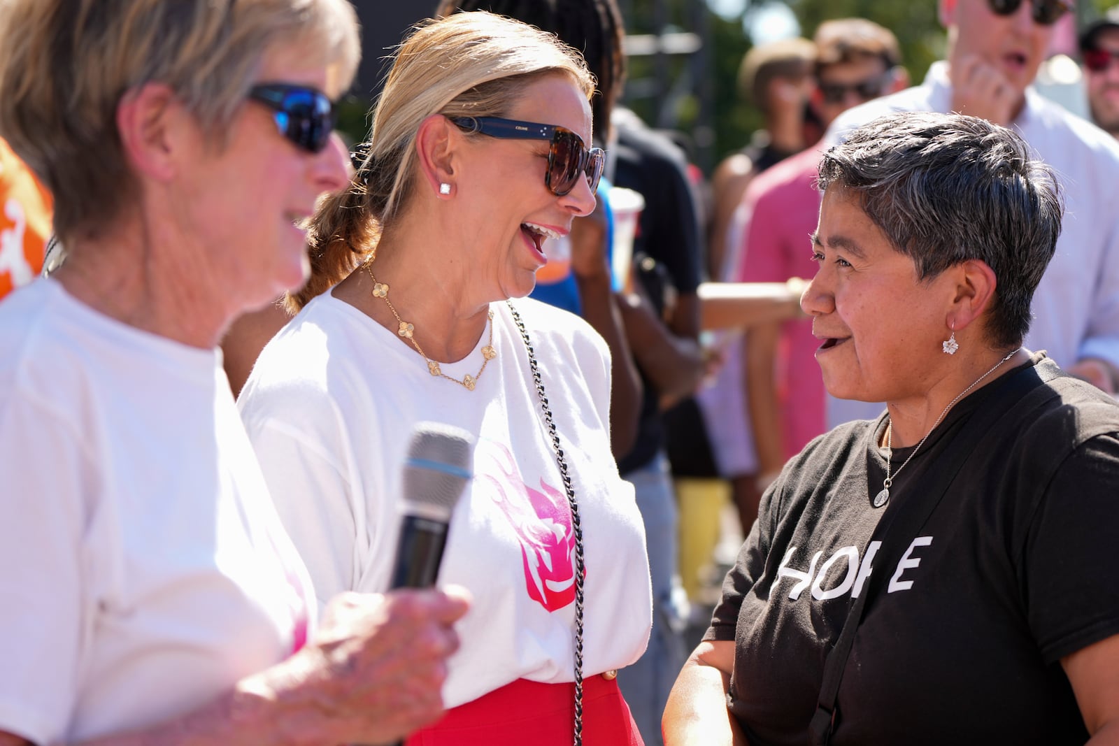 Portland Fire's interim president Clare Hamill, left, looks on as Portland Fire coowner Lisa Bhathal Merage, center, talks with fan Valerie Moreno, right, during a launch event announcing Portland Fire as the name of Portland's WNBA basketball franchise at the Moda Center on Tuesday, July 15, 2025, in Portland, Ore. (AP Photo/Jenny Kane)
