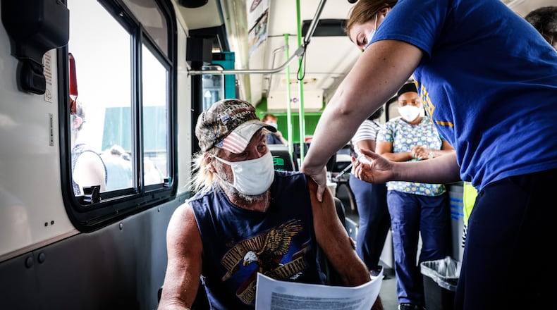 Lonnie Stanfill from Riverside gets a COVID-19 shot from Blaire Fogle RN at the Dayton Metro Library in Huber Heights. Dayton and Montgomery County Public Health parked the mobil clinic in the parking lot of the library and offered $100 gift card for everyone that gets a vaccine. Jim Noelker/Staff