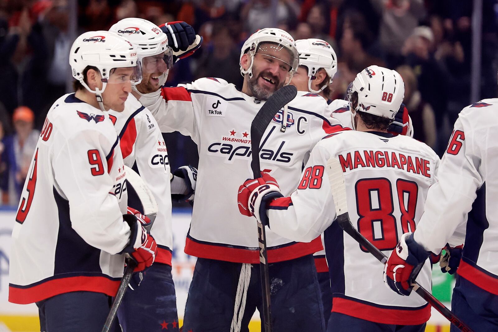 Washington Capitals left wing Alex Ovechkin (8) celebrates with is teammates after scoring against New York Islanders during the second period of an NHL hockey game in Elmont, N.Y., Sunday, April 6, 2025. (AP Photo/Adam Hunger)