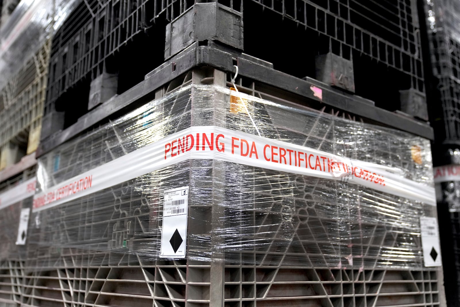 Containers of material wait in a warehouse for certification by the Food and Drug Administration at Sensient Technologies Corp., a color additive manufacturing company, in St. Louis., on Wednesday, April 2, 2025. (AP Photo/Jeff Roberson)