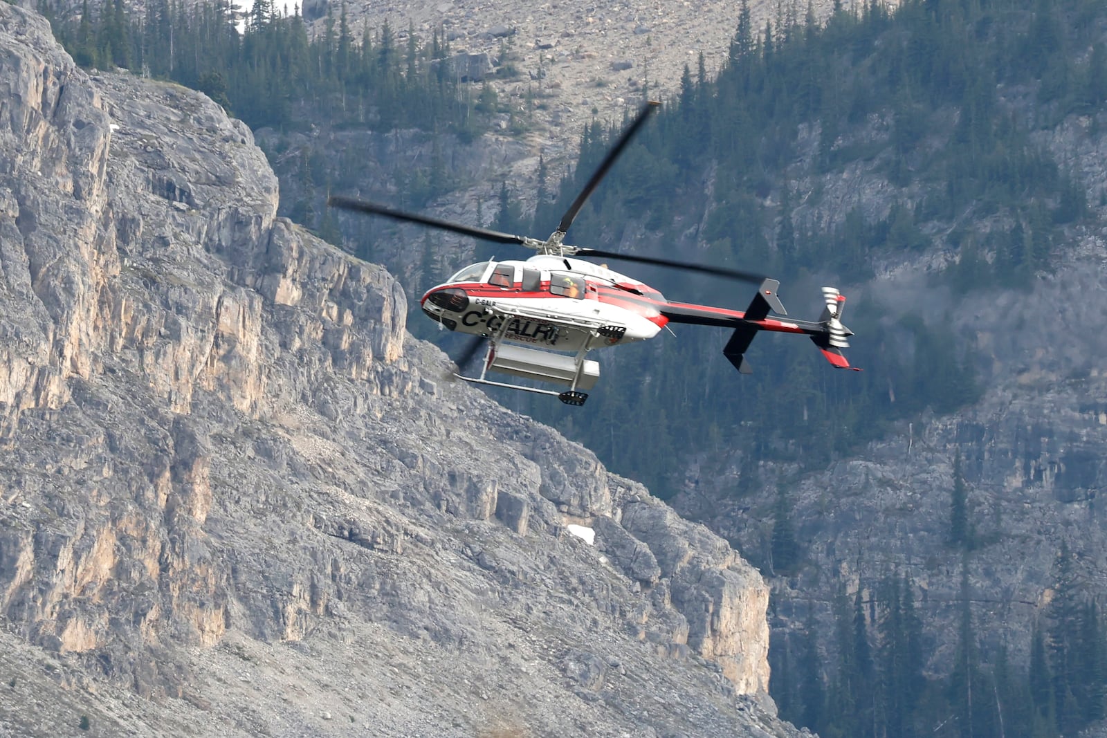A helicopter is seen close to the scene of a rock slide near Bow Glacier Falls, north of Lake Louise, Alta. in Banff National Park on Thursday, June 19, 2025. (Larry MacDougal/The Canadian Press via AP)