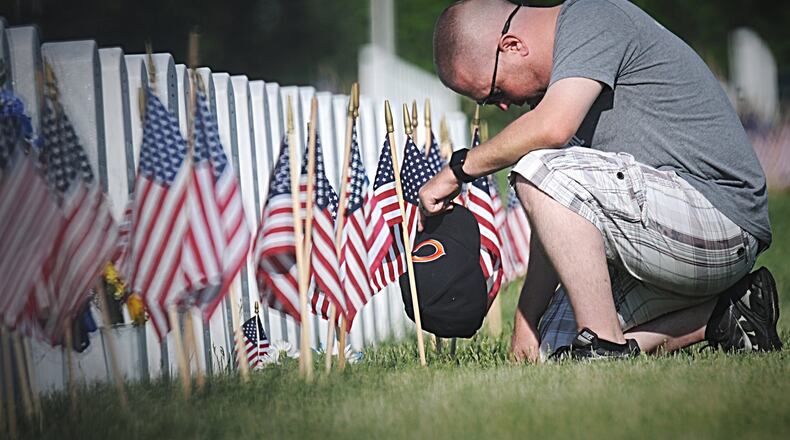 Donald King, of Piqua, pays his respects to his father, a Korean war veteran at the National Cemetery in Dayton on Memorial Day. MARSHALL GORBY / STAFF