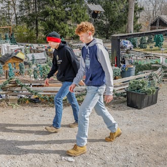 Wyatt Pyles, left, and Derek Orr walk past Christmas decorations on Monday, November 24, 2025, at Clifton Mill. JOSEPH COOKE/STAFF