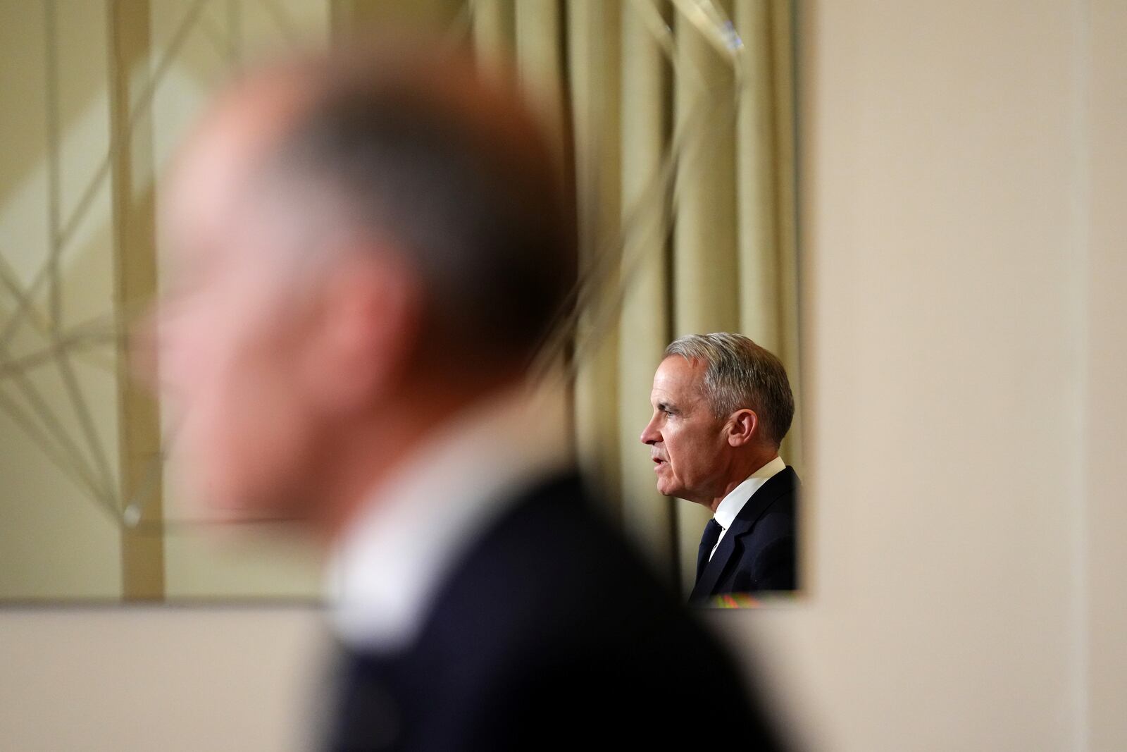 FILE - Canada's Prime Minister Mark Carney, reflected in a mirror, speaks to media during a press conference at Canada House in London on March 17, 2025. (Sean Kilpatrick/The Canadian Press via AP, File)