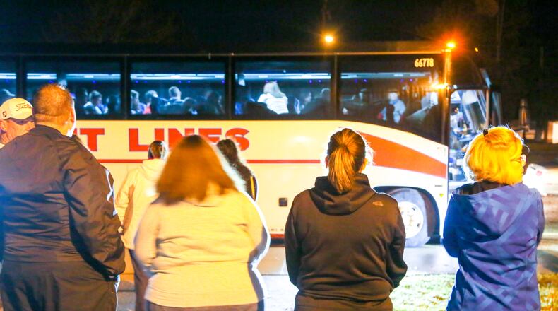 Parents watch as students from local schools board a charter bus heading to Washington, D.C., early Wednesday morning. The group is traveling to see President-Elect Donald Trump’s inauguration and other sites. GREG LYNCH / STAFF