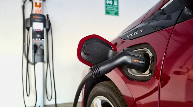 FILE - This Oct. 17, 2018 photo shows a Chevrolet Volt hybrid car charging at a ChargePoint charging station at a parking garage in Los Angeles. The country, and the world, will need thousands more for drivers to accept vehicles that are powered by batteries alone. But automakers and charging companies are struggling to raise the numbers now because they’re investing before demand arrives. With more than 40 fully electric vehicles on the market in the U.S. or coming within the next three years, however, auto and charging company executives say the demand is on the way.(AP Photo/Richard Vogel, File)