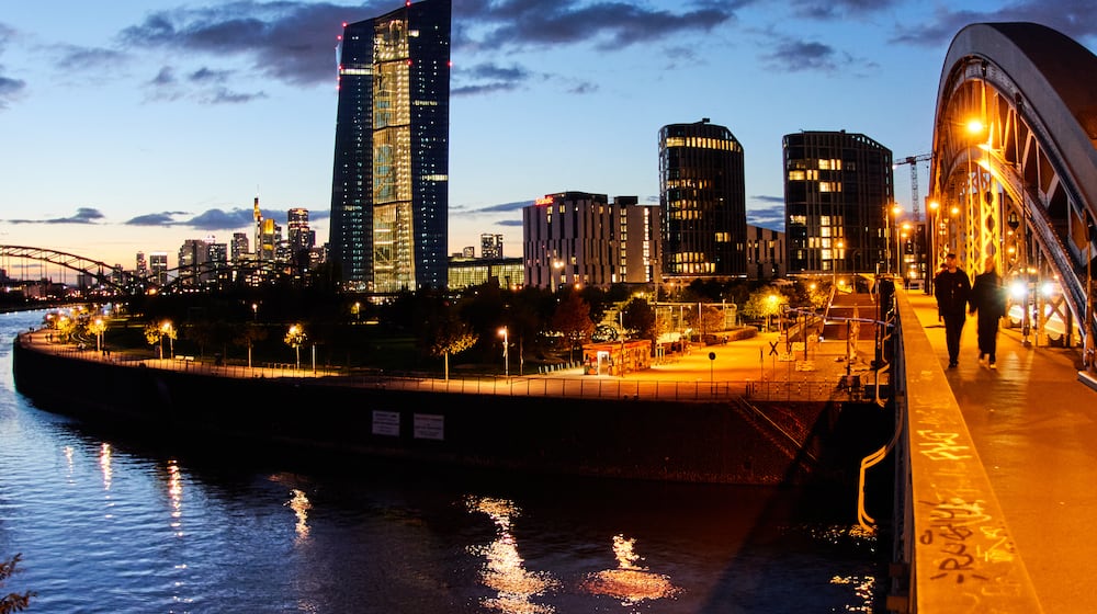 People walk over a bridge near the European Central Bank in Frankfurt, Germany, Sunday, Oct. 26, 2025. (AP Photo/Michael Probst)