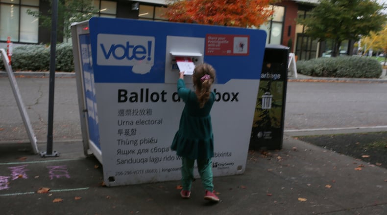 FILE -Olive, 4, deposits an election ballot into a drop box in Seattle, Wash. under the supervision of her mother, on Nov. 4, 2025. (AP Photo/Cedar Attanasio, File)