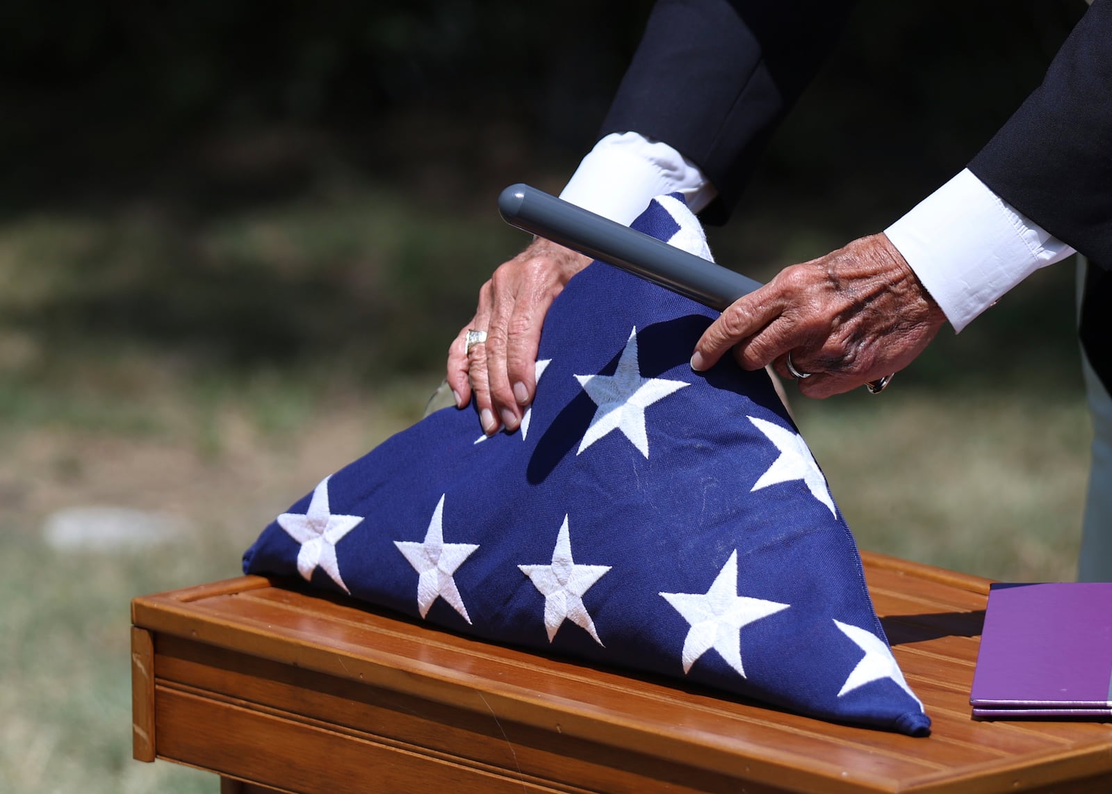 Deacon Glenn Tylutki, of Chicago Catholic Cemeteries, adjusts an American flag prior to a military funeral for 75-year-old Pfc. Reba C. Bailey, a former missing person cold case named Seven Doe, Tuesday, July 1, 2025, at Mount Olivet Catholic Cemetery in Chicago. (AP Photo/Talia Sprague)