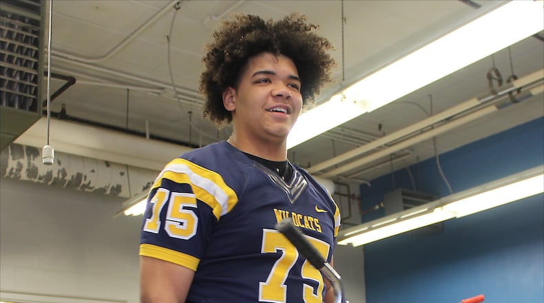 Springfield High School football player, Isaiah Gibson helps deliver a bicycle to a family in need for Christmas last week. The Springfield High School football team helped a local family of seven with gifts and three bicycles. JEFF GUERINI/STAFF