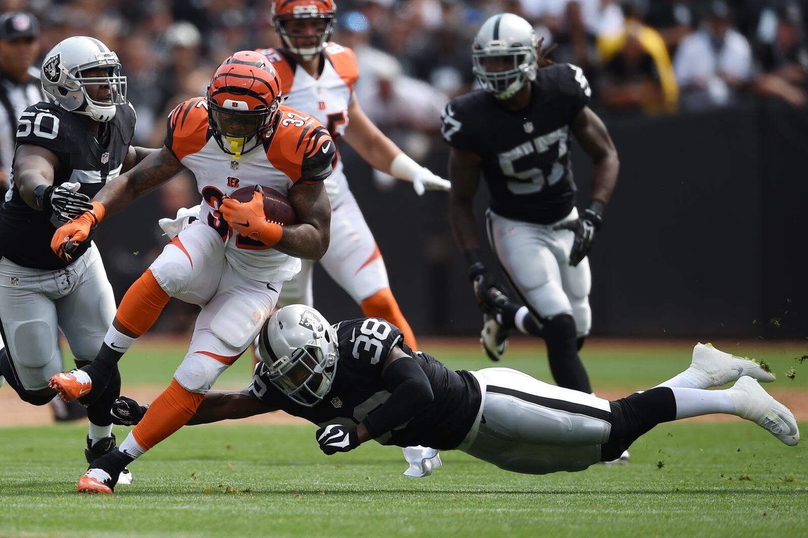 OAKLAND, CA - SEPTEMBER 13: Jeremy Hill #32 of the Cincinnati Bengals is hit by Keith McGill #39 of the Oakland Raiders during the first half of their NFL game at O.co Coliseum on September 13, 2015 in Oakland, California. (Photo by Thearon W. Henderson/Getty Images)