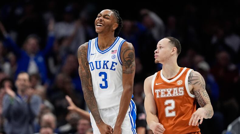 Duke guard Isaiah Evans celebrates after scoring as Texas guard Chendall Weaver looks on during the first half of an NCAA college basketball game, Tuesday, Nov. 4, 2025, in Charlotte, N.C. (AP Photo/Chris Carlson)
