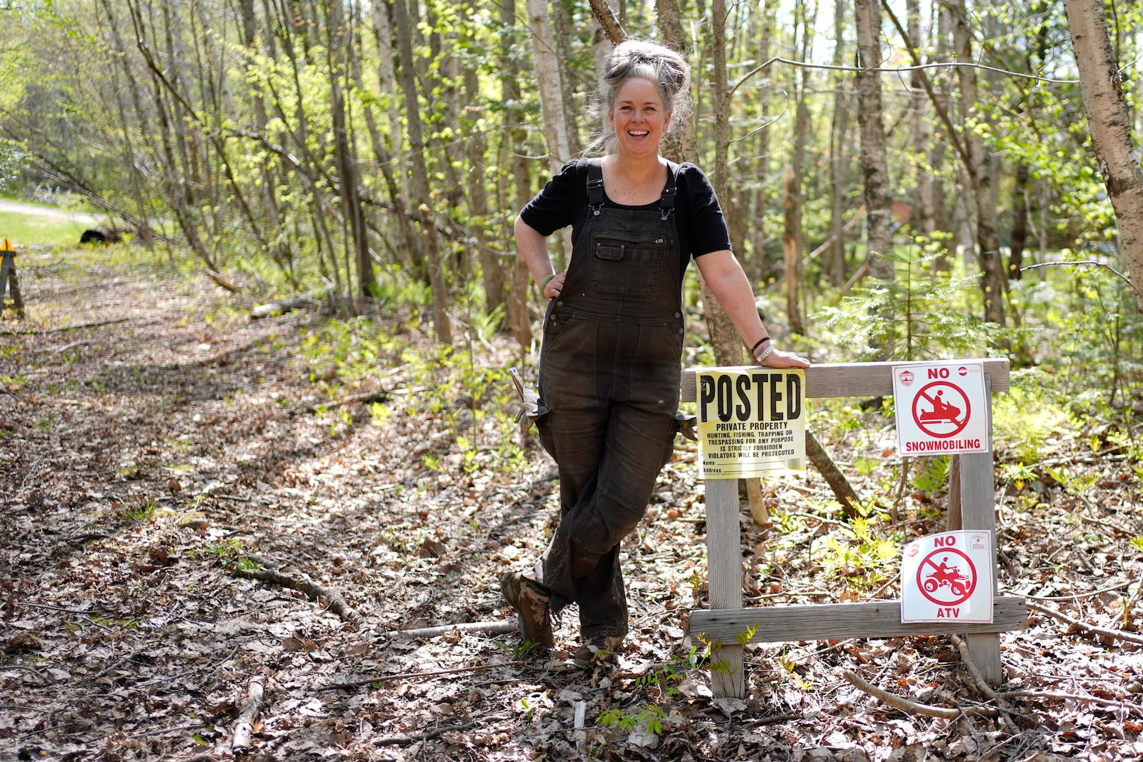 Heather Donahue, the star of the 1999 low-budget hit movie The Blair Witch Project, poses next to a "posted" sign in on a rural road, Tuesday, May 13, 2025, in Freedom, Maine. (AP Photo/Robert F. Bukaty)