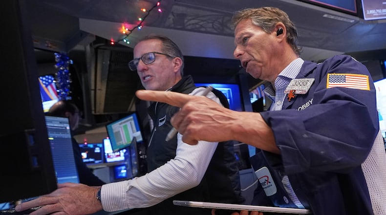 Specialist Glenn Carell, left, and trader Robert Charmak work on the floor of the New York Stock Exchange, Thursday, Dec. 11, 2025. (AP Photo/Richard Drew)