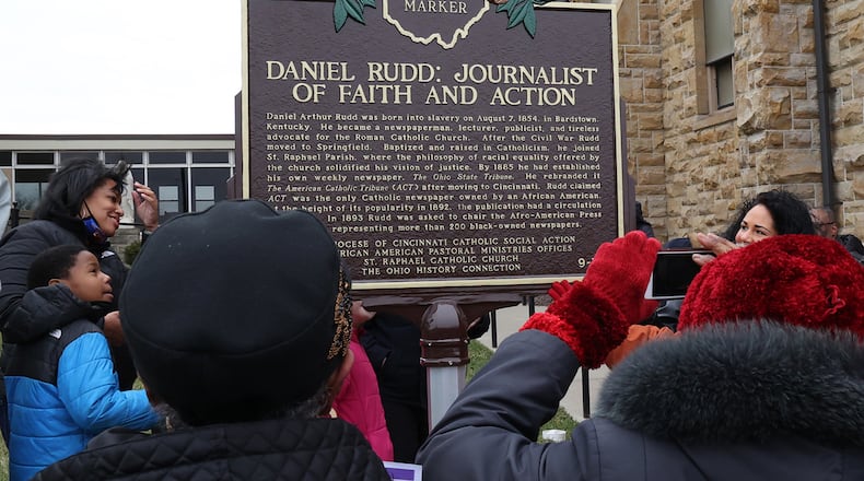 A crowd gathered outside St. Raphael Catholic Church in Springfield takes pictures of a Historic Marker that was unveiled for Daniel Rudd Sunday afternoon. Rudd, who lived in Springfield for most of his life in the late 19th and early 20th century, was an African American Catholic, a newspaper publisher and an early civil rights leader. BILL LACKEY/STAFF