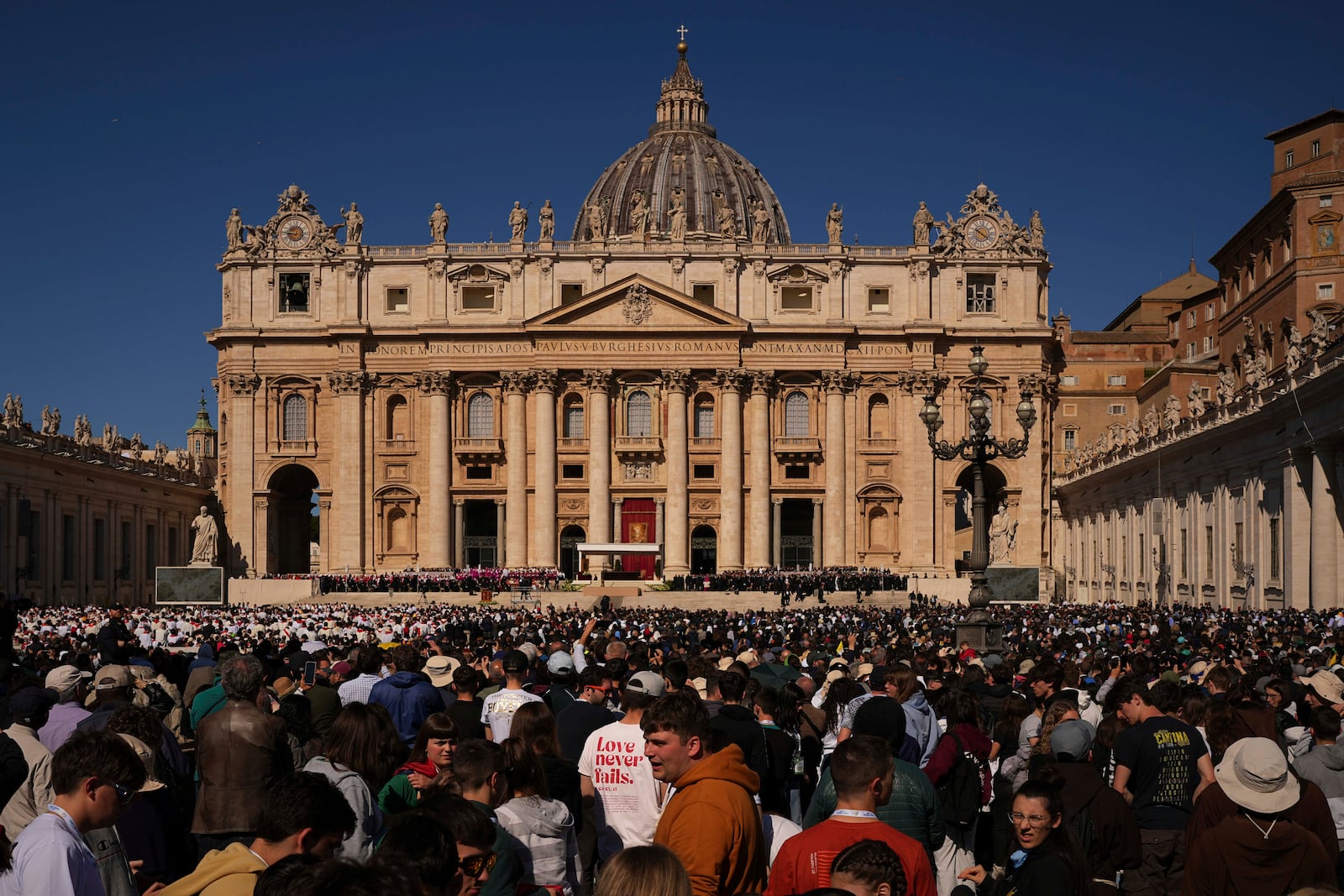 People wait before the funeral of Pope Francis in St. Peter's Square at the Vatican, Saturday, April 26, 2025. (AP Photo/Andreea Alexandru)