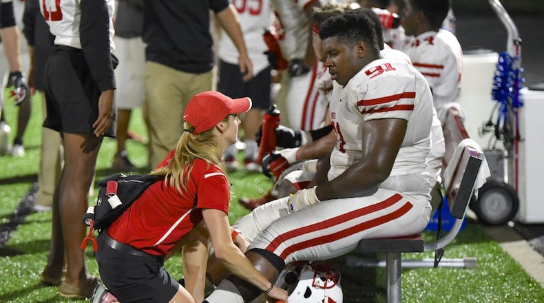 House Bill 176, jointly sponsored by Reps. Thomas Hall, R-Madison Twp., and Rick Carfagna, R-Genoa Twp., would provide athletic trainers the option to enter into a collaboration agreement with a physician or podiatrist to allow that athletic trainer to perform additional services and activities. Ohio House members passed the bill 95-0 on Friday and it moves to the Ohio Senate for consideration. The practice act for athletic trainers hasn’t been updated in 30 years. Pictured is Lakota West High School trainer Carlee Shafer with a Lakota West football player in 2018. FILE