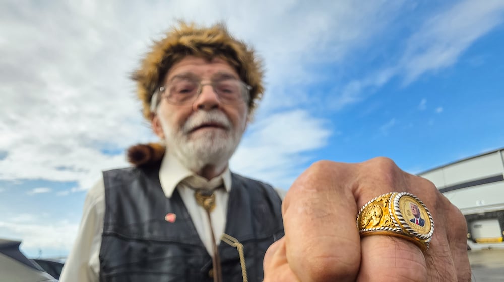 Donald Wenzel shows off is President Trump ring as he waits in line for a Trump visit at Verst Logistics Wednesday, March 11, 2026 in Hebron, Kentucky. NICK GRAHAM/STAFF