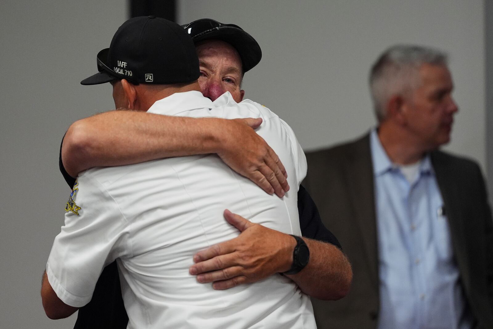Kootenai County Fire & Rescue commissioner Andy Boyle, facing, gets a hug following a press conference announcing the names of the firefighters killed and wounded the day before by a shooter while responding to a wildfire at Canfield Mountain, Monday, June 30, 2025, in Post Falls, Idaho. (AP Photo/Lindsey Wasson)