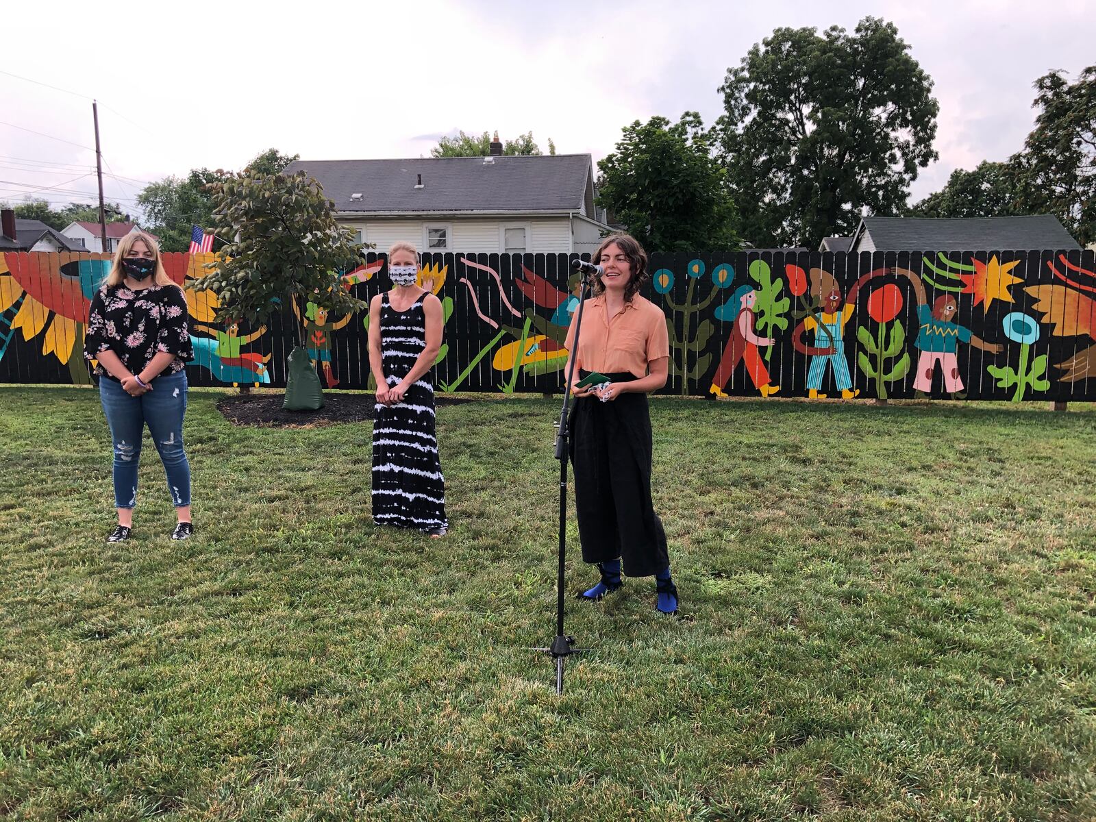 Residents of the Jefferson neighborhood gathered Tuesday to dedicate the new mural, Garden Parade, in the two-year-old Jefferson Park. The mural's designer and main painter, Lizzy DuQuette, is shown speaking. MIKE RUTLEDGE/STAFF