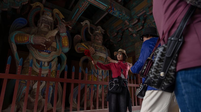 A guide briefs visitors at the Bulguksa Temple where preparations are underway ahead of events for attendees of the Asia-Pacific Economic Cooperation (APEC) summits in Gyeongju, South Korea, Thursday, Oct. 30, 2025. (AP Photo/Ng Han Guan)