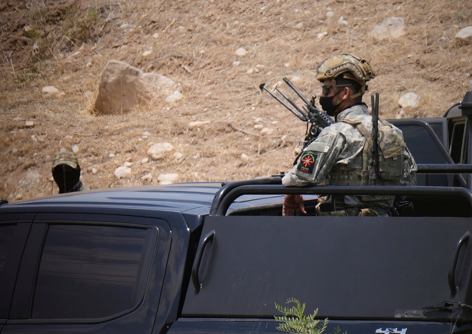 Forces of the regional Kurdish administration secure the area of the Jasana Cave ahead of a symbolic disarmament ceremony by the separatist PKK group as part of the peace process with Turkey, in Sulaymaniyah governorate, Iraq, Friday, July 11, 2025. (AP Photo/Hadi Mizban)