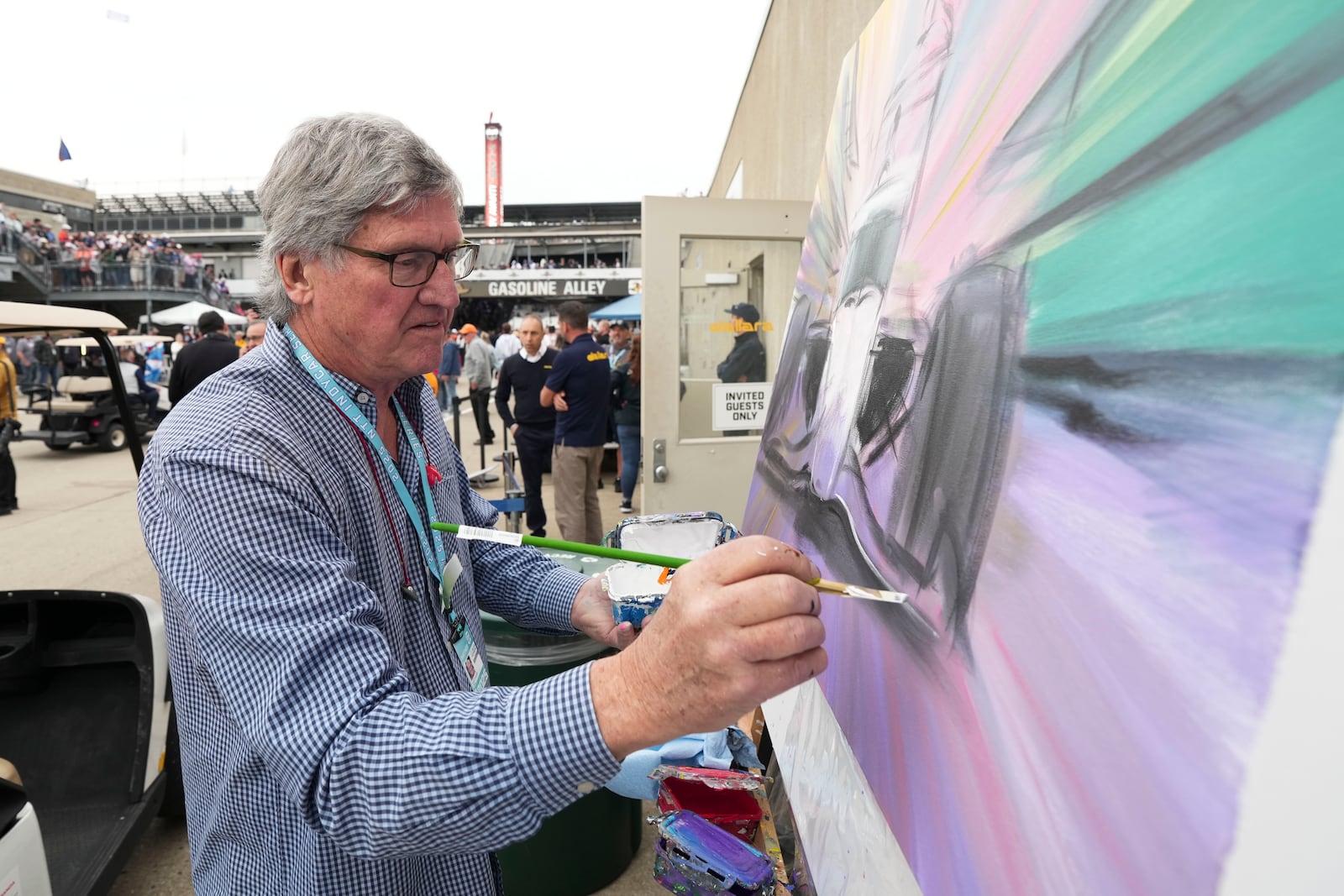 Artist William Patterson paints in Gasoline Alley before the start of the Indianapolis 500 auto race at Indianapolis Motor Speedway in Indianapolis, Sunday, May 25, 2025. (AP Photo/AJ Mast)