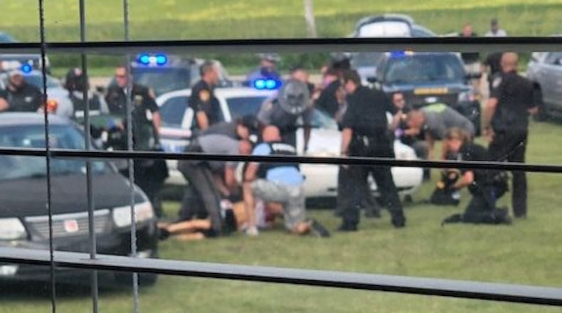 As seen from inside a Turtlecreek Twp. home Monday as law enforcement officers from several agencies secure Christopher J. Hubbard after he shot Middletown police officer Dennis Jordan Aug. 31 following a lengthy police pursuit that ended in the front yard of North Mason-Montgomery Road residence. Dozens of rounds were fired between Hubbard and several police officers before he was taken into custody. Jordan and Hubbard received gunshot wounds and were taken to area hospitals. CONTRIBUTED/TONY THORNTON