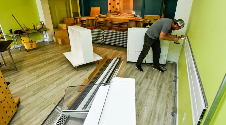Kevin Kimener installs a slat wall at the new Vitori’s Market behind Gracie’s restaurant in Torchlight Pass building on Central Avenue in Middletown. Vitori’s Market will offer groceries, specialty and locally grown items and a selection of Gracie’s food. An online store will be set up to order groceries and specials for takeout, and delivery. NICK GRAHAM / STAFF