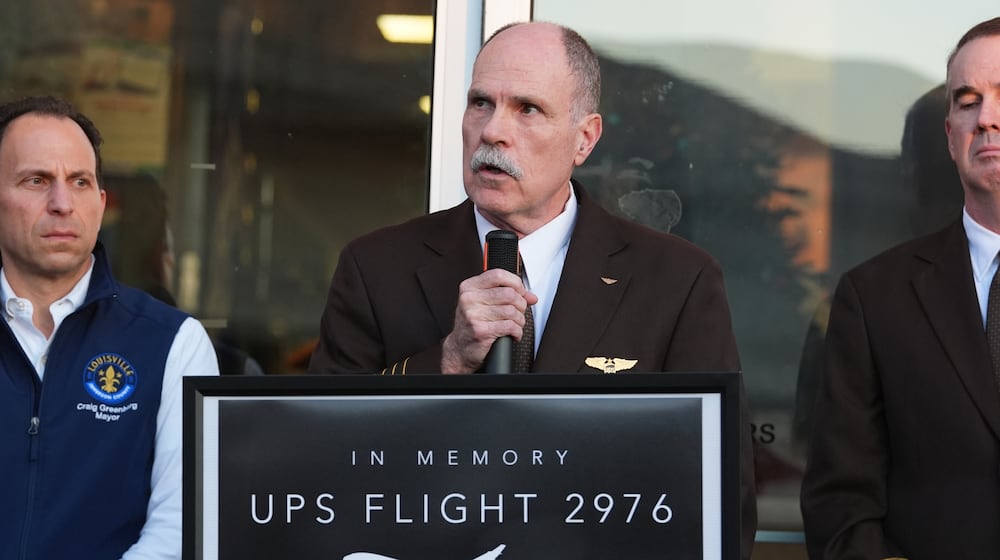 Independent Pilots Association President Bob Travis, center, speaks during a vigil Thursday, Nov. 6, 2025, in Louisville, Ky., after a UPS plane crashed at Louisville Muhammad Ali International Airport. (AP Photo/Darron Cummings)