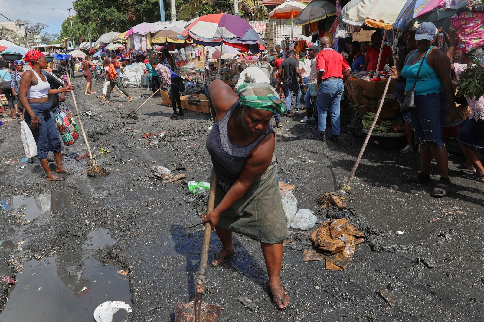 Vendors clean a street before starting to sell their goods in the Petion-ville neighborhood of Port-au-Prince, Haiti, Friday, May 16, 2025. (AP Photo/Odelyn Joseph)