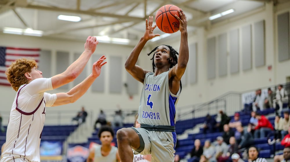 Dunbar High School sophomore Kevin Jackson drives to the hoop against Lebanon junior Luke Faler during their game at The Beacon Orthopaedics Flyin' to the Hoop Invitational in January at Kettering's Trent Arena. MICHAEL COOPER/CONTRIBUTED