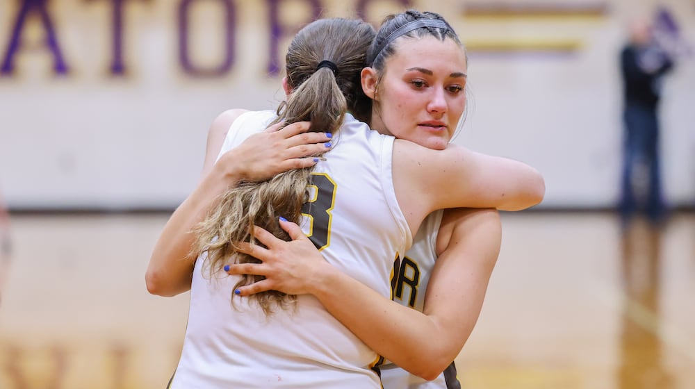 Alter senior forward Samantha Pothast hugs junior guard Molly Miller following a 50-34 loss to Cincinnati Purcell Marian in a Division IV regional final on Saturday, March 7 at Vandalia-Butler's Student Activity Center. BRYANT BILLING / STAFF
