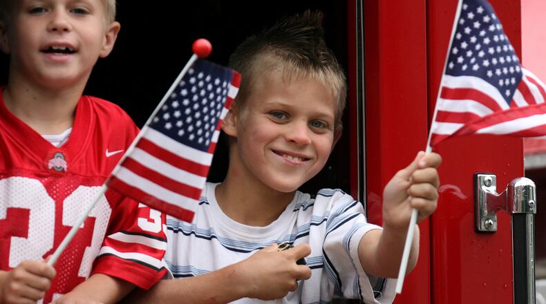 Kids wave from a fire truck during past Fourth of July parade on Verity Parkway in Middletown. FILE