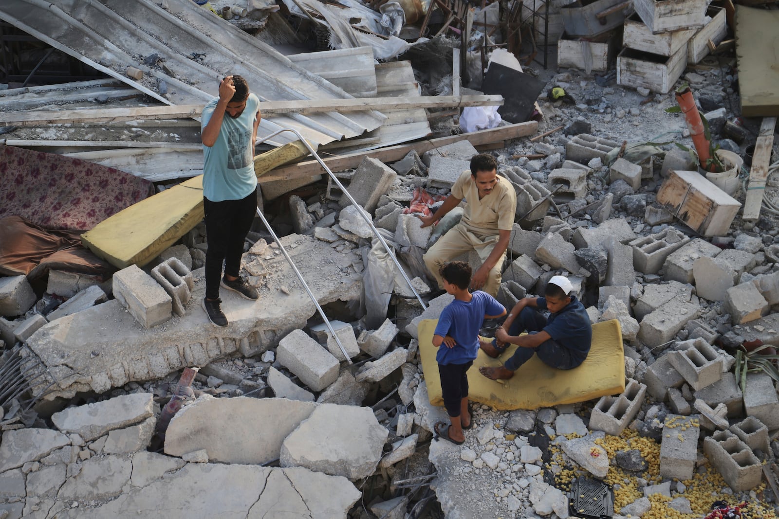 Palestinians inspect the site struck by an Israeli bombardment in Muwasi, Khan Younis, Gaza Strip, Monday, July 28, 2025. (AP Photo/Mariam Dagga)