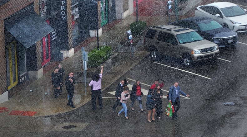 People hustle across Third Street as the month of March comes in like a lion on Friday March 11, 2022. MARSHALL GORBY\STAFF