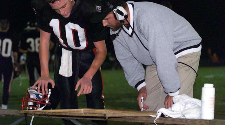 Matt Hopkins is Preble Shawnee’s head football coach, but he used to play quarterback for the Arrows. He is shown receiving instructions from PS coach Rick Newsock during a game against Dixie on Oct. 30, 1998. COX MEDIA FILE PHOTO