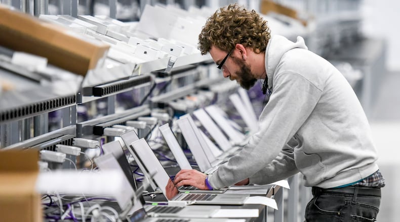 Configuration technician Max Faeth configures computers at CompuCom Thursday, Dec. 29, 2016 in Fairfield. NICK GRAHAM/STAFF