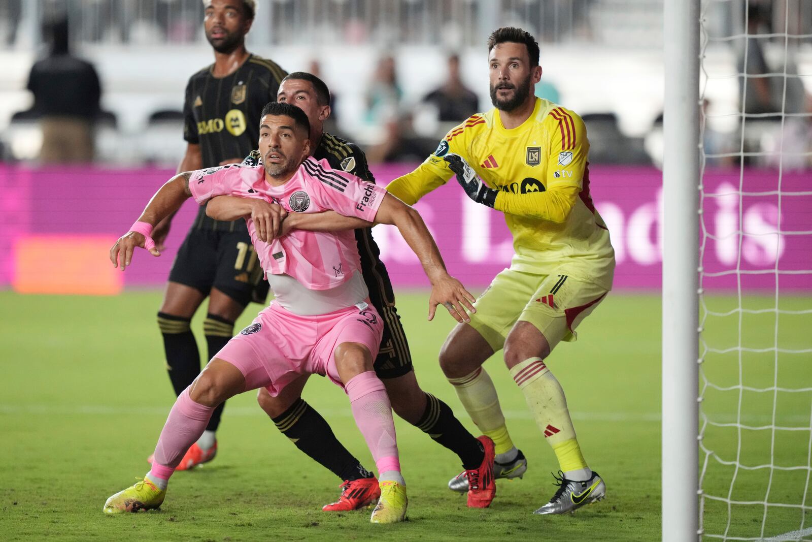 Inter Miami forward Luis Suárez (9) battles for position during a corner kick with Los Angeles FC defender Sergi Palencia (14) as goalkeeper Hugo Lloris (1) looks on during the first half of a CONCACAF Nations League Quarterfinal Match at Chase Stadium, Wednesday, April 9, 2025 in Fort Lauderdale, Fla. (AP Photo/Jim Rassol)