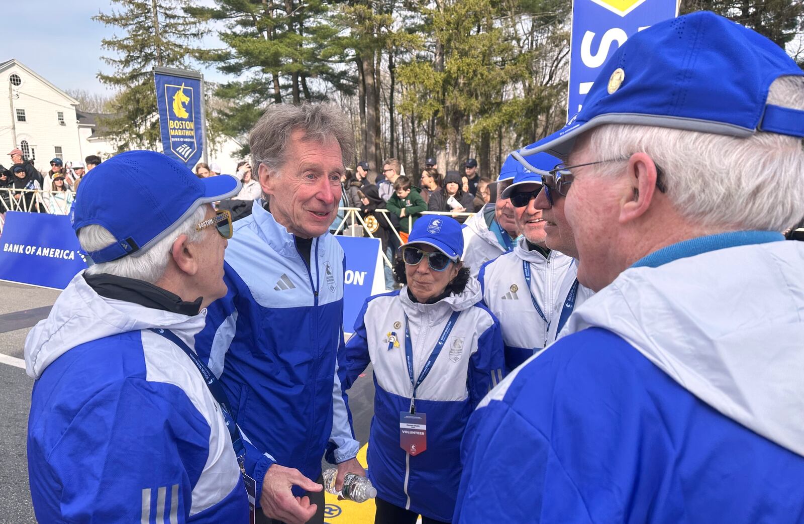 Four-time Boston Marathon winner Bill Rodgers and wheelchair athlete pioneer Bob Hall greet race volunteers at the start of the Boston Marathon Monday, April 21, 2025. They are the grand marshals of the 129th Boston Marathon. (AP Photo/ Jennifer McDermott)