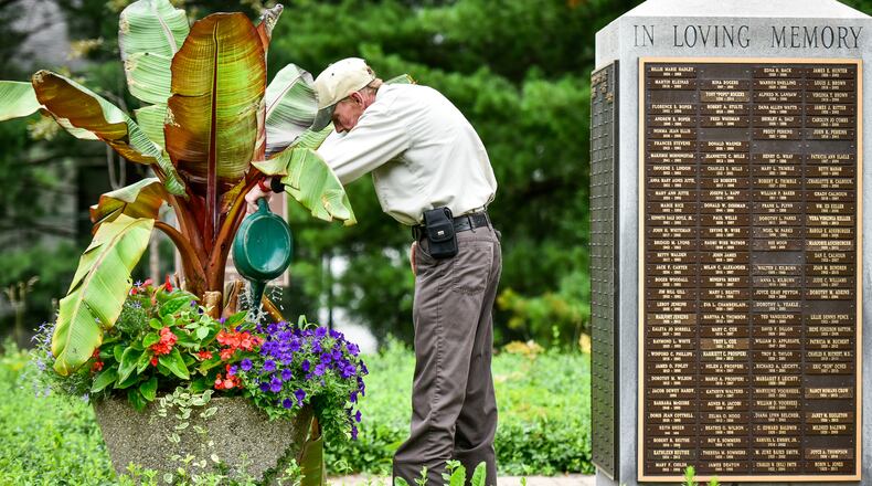 Jeff Kellum waters the planters at the Cremation Scattering Garden at Woodside Cemetery and Arboretum in Middletown. Woodside recently purchased two parcels located at 1135 and 1119 Lafayette Ave. for expansion of the cemetery. The cost was $500 for each parcel for a total of $1,000. NICK GRAHAM/STAFF