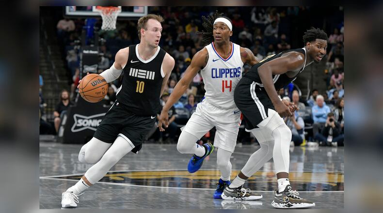 Memphis Grizzlies guard Luke Kennard (10) drives as Los Angeles Clippers guard Terance Mann (14) works around a screen by Grizzles' Jaren Jackson Jr. during the second half of an NBA basketball game Friday, Feb. 23, 2024, in Memphis, Tenn. (AP Photo/Brandon Dill)