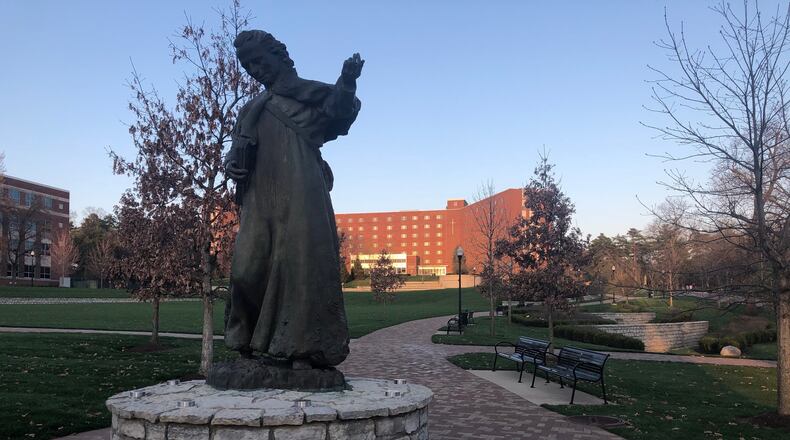 Wednesday was a sunny 75-degree April day at the University of Dayton, but the statue of Marianist founder William Chaminade oversaw a nearly empty campus. Residence halls, like the Marycrest Complex in the background, are almost empty due to coronavirus-related closures. JEREMY P. KELLEY / STAFF