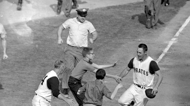 FILE - In this Oct. 13, 1960 file photo, jubilant Pittsburgh Pirates fans rush onto the field to congratulate second baseman Bill Mazeroski as he rounds third base after hitting a ninth inning home run to win Game 7 of baseball's World Series against the New York Yankees in Pittsburgh, Pa., on Oct. 13, 1960. (AP Photo/Harry Harris, File)